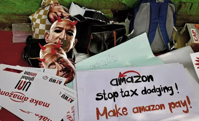 Paper masks in the likeness of Amazon's Jeff Bezos, and banners wait to be distributed to warehouse workers and delivery drivers as they stage a protest against the Seattle-based company, demanding higher wages and better working conditions, in New Delhi, India, Friday, Nov. 29, 2024. (AP Photo/Manish Swarup)