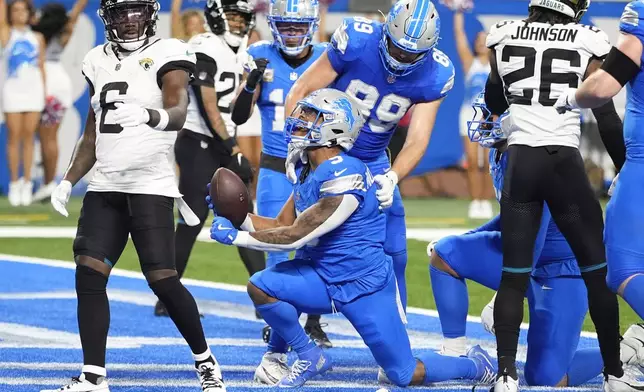 Detroit Lions running back David Montgomery (5) celebrates his six-yard touchdown run against the Jacksonville Jaguars during the first half of an NFL football game, Sunday, Nov. 17, 2024, in Detroit. (AP Photo/Carlos Osorio)