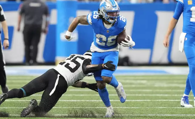 Detroit Lions running back Jahmyr Gibbs (26) tries to break the tackle of Jacksonville Jaguars cornerback Ronald Darby (25) during the first half of an NFL football game, Sunday, Nov. 17, 2024, in Detroit. (AP Photo/Carlos Osorio)