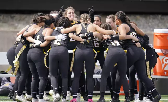 FILE - Ottawa University women's flag football team cheers before an NAIA flag football game against Midland University in Ottawa, Kan., Friday, March 26, 2021. (AP Photo/Orlin Wagner, File)