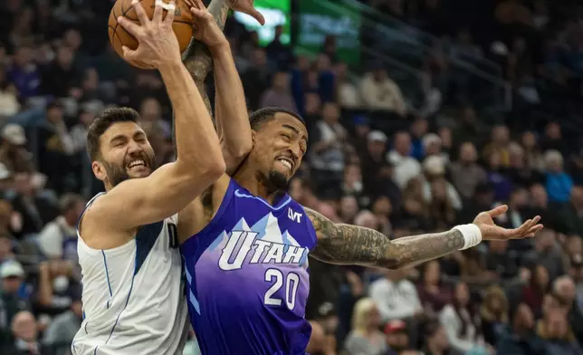 Dallas Mavericks forward Maxi Kleber, left, gets tangled up with Utah Jazz forward John Collins (20) during the first half of an NBA basketball game Thursday, Nov. 14, 2024, in Salt Lake City. (AP Photo/Rick Egan)