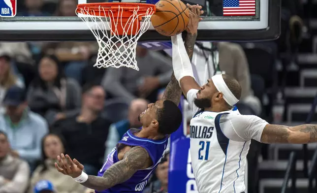 Dallas Mavericks center Daniel Gafford (21) blocks a shot by Utah Jazz forward John Collins, left, during the first half of an NBA basketball game Thursday, Nov. 14, 2024, in Salt Lake City. (AP Photo/Rick Egan)