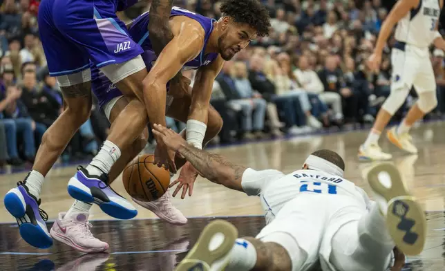 Dallas Mavericks center Daniel Gafford (21) goes for the ball along with Utah Jazz guard Johnny Juzang, second from left, during the first half of an NBA basketball game Thursday, Nov. 14, 2024, in Salt Lake City. (AP Photo/Rick Egan)