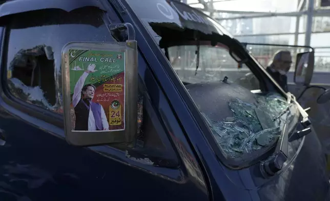 A poster of imprisoned former premier Imran Khan is displayed on a damaged vehicle left behind by supporters of Khan's Pakistan Tehreek-e-Insaf party after clashes with security forces the night before, in Islamabad, Pakistan, Wednesday, Nov. 27, 2024. (AP Photo/Anjum Naveed)