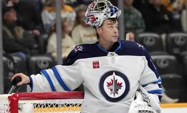 Winnipeg Jets goaltender Eric Comrie looks up at the scoreboard during the second period of an NHL hockey game against the Nashville Predators, Saturday, Nov. 23, 2024, in Nashville, Tenn. (AP Photo/Mark Humphrey)