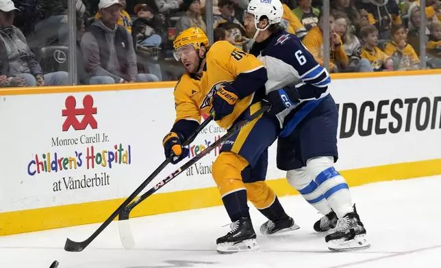 Nashville Predators center Jonathan Marchessault (81) passes the puck away from Winnipeg Jets defenseman Colin Miller (6) during the second period of an NHL hockey game Saturday, Nov. 23, 2024, in Nashville, Tenn. (AP Photo/Mark Humphrey)