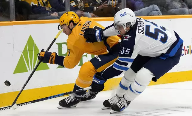 Nashville Predators defenseman Jeremy Lauzon, left, chases down the puck with Winnipeg Jets center Mark Scheifele (55) during the first period of an NHL hockey game Saturday, Nov. 23, 2024, in Nashville, Tenn. (AP Photo/Mark Humphrey)