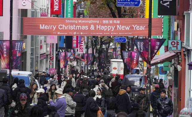 People walk on the shopping street in Seoul, South Korea, Thursday, Nov. 28, 2024.(AP Photo/Ahn Young-joon)