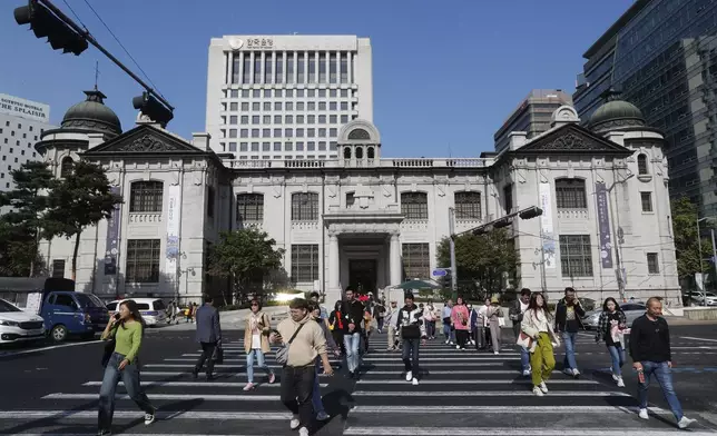 FILE - People pass by the headquarters of the Bank of Korea in Seoul, South Korea, Oct. 16, 2019. (AP Photo/Ahn Young-joon, File)