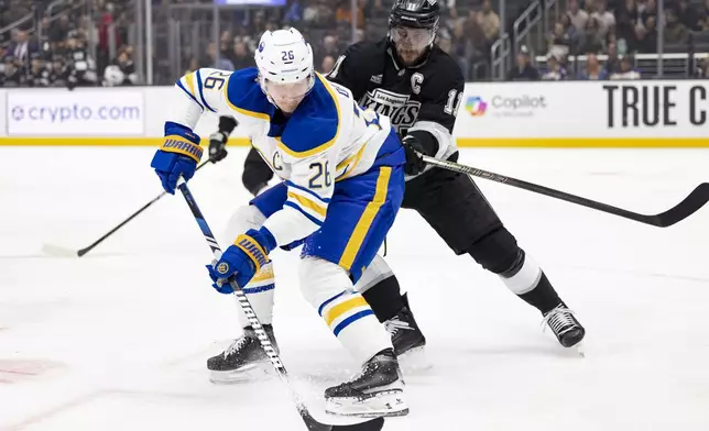 Buffalo Sabres defenseman Rasmus Dahlin, left, and Los Angeles Kings center Anze Kopitar vie for the puck during the first period of an NHL hockey game Wednesday, Nov. 20, 2024, in Los Angeles, Calif. (AP Photo/Ryan Sun)