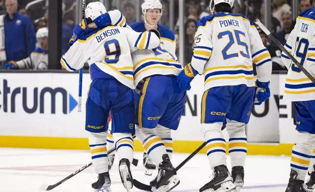 Buffalo Sabres left wing Beck Malenstyn, center, is helped off the ice by left wing Zach Benson, left, and defenseman Owen Power during the second period of an NHL hockey game against the Los Angeles Kings, Wednesday, Nov. 20, 2024, in Los Angeles, Calif. (AP Photo/Ryan Sun)