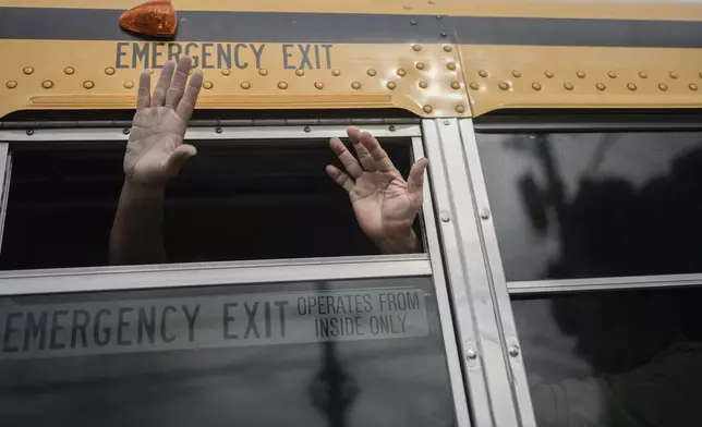 FILE - Exiled Nicaraguans released from a Nicaraguan jail wave from a bus after arriving at the airport in Guatemala City, Sept. 5, 2024. (AP Photo/Moises Castillo, File)