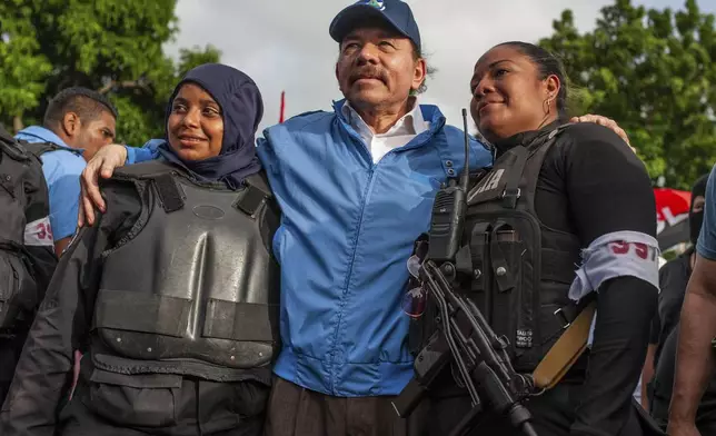 FILE - President Daniel Ortega poses for a photo with Nicaraguan riot police, after weeks of unrest in Masaya, Nicaragua, July 13, 2018. (AP Photo/Cristobal Venegas, File)