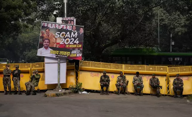 Security officials stand during a protest against Indian billionaire Gautam Adani and Indian Prime Minister Narendra Modi, after Adani was indicted by U.S. prosecutors for bribery and fraud, in New Delhi, India, Monday, Nov. 25, 2024. (AP Photo/Manish Swarup)