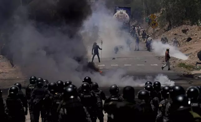 FILE - Police launch tear gas to disperse backers of former President Evo Morales who have been blocking roads for weeks partly targeting President Luis Arce's handling of the economy, in Parotani, Bolivia, Nov. 1, 2024. (AP Photo/Juan Karita, File)