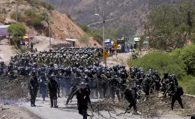 FILE - Police clear a road blocked by supporters of former President Evo Morales who have been blocking roads for weeks partly targeting President Luis Arce's handling of the economy, in Parotani, Bolivia, Nov. 1, 2024. (AP Photo/Juan Karita, File)