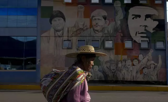 FILE - A woman walks past a mural featuring socialist leaders, from left; former Bolivian President Evo Morales, late Venezuelan President Hugo Chavez and revolutionary Ernesto "Che: Guevara, at the bus terminal in Sacaba, Bolivia, Nov. 20, 2024. (AP Photo/Juan Karita, File)