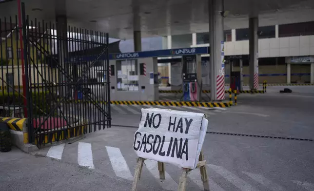 FILE - A sign alerts customers that there is no gasoline at a fuel station after five days of roadblocks by supporters of former President Evo Morales affecting the fuel and food supply, in La Paz, Bolivia, Oct. 21, 2024. (AP Photo/Juan Karita, File)