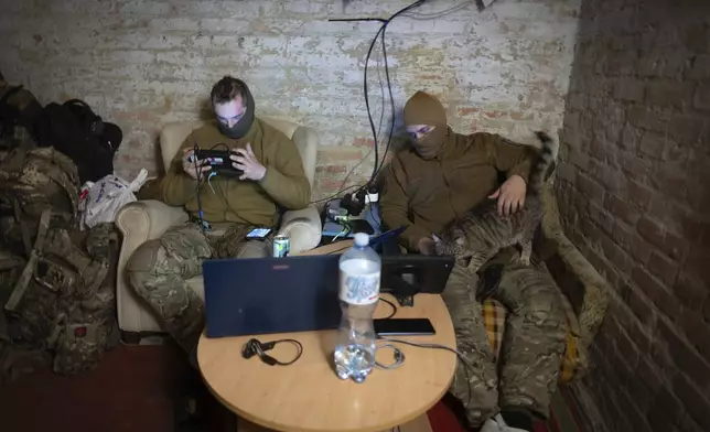 Servicemen of Ukraine's Khartia brigade pilot drones in a shelter on the frontline near Kharkiv, Ukraine, late Thursday, Nov. 7, 2024. (AP Photo/Efrem Lukatsky)