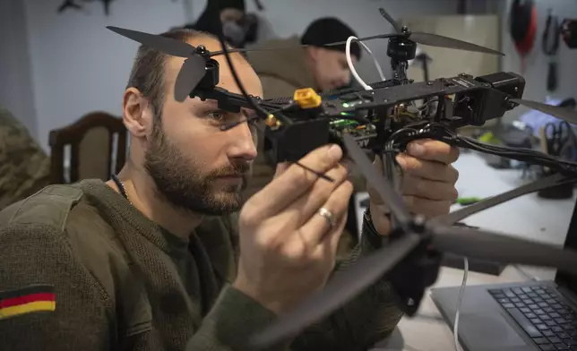 A soldier of Ukraine's Khartia brigade, callsign Tolstiy, inspects a FPV drone in a drone repair workshop close to the front line in the Kharkiv region, Ukraine, Thursday, Nov. 7, 2024. (AP Photo/Efrem Lukatsky)