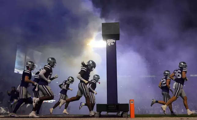 Kansas State players run onto the field before an NCAA college football game against Arizona State Saturday, Nov. 16, 2024, in Manhattan, Kan. (AP Photo/Charlie Riedel)