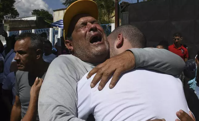 Cesar Salmeron, left, embraces his son Antony Salmeron upon his release from prison in Tocuyito, Venezuela, Saturday, Nov. 16, 2024. Antony Salmeron was detained during a government crackdown following anti-government protests against the results of the presidential election. (AP Photo/Jacinto Oliveros)