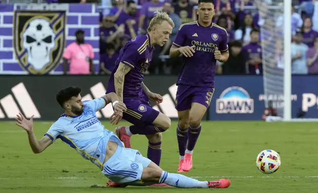 Atlanta United's Pedro Amador, left, clears the ball away from Orlando City's Dagur Thorhallsson, center, and Cesar Araujo (5) during the first half of an MLS Semifinal Conference playoff soccer match, Sunday, Nov. 24, 2024, in Orlando, Fla. (AP Photo/John Raoux)