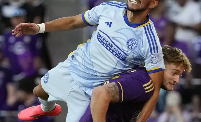 Atlanta United's Luis Abram, ltop, jumps over Orlando City's Duncan McGuire, bottom to control a head ball during the second half of an MLS Semifinal Conference playoff soccer match, Sunday, Nov. 24, 2024, in Orlando, Fla. (AP Photo/John Raoux)