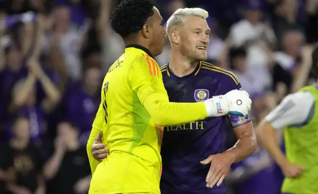 Orlando City goalkeeper Pedro Gallese, left, and defender Robin Jansson celebrate after defeating Atlanta United in an MLS Semifinal Conference playoff soccer match, Sunday, Nov. 24, 2024, in Orlando, Fla. (AP Photo/John Raoux)