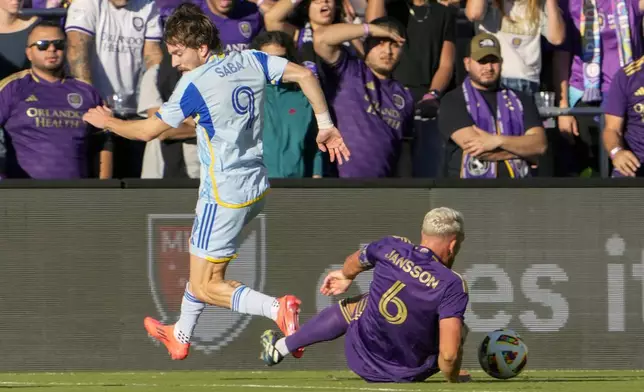 Orlando City's Robin Jansson (6) steals the ball from Atlanta United's Saba Lobzhanidze (9) during the first half of an MLS Semifinal Conference playoff soccer match, Sunday, Nov. 24, 2024, in Orlando, Fla. (AP Photo/John Raoux)