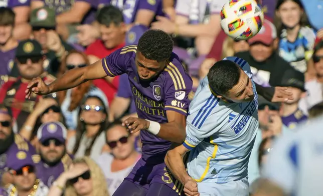 Orlando City's Rafael Santos, left, and Atlanta United's Bartosz Slisz, right, battle for a head ball during the first half of an MLS Semifinal Conference playoff soccer match, Sunday, Nov. 24, 2024, in Orlando, Fla. (AP Photo/John Raoux)