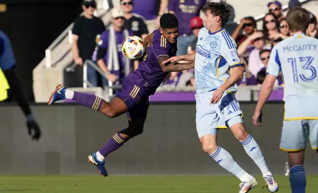 Orlando City's Wilder Cartagena, left, tries to get possession of the ball in front of Atlanta United's Aleksey Miranchuk (59) during the first half of an MLS Semifinal Conference playoff soccer match, Sunday, Nov. 24, 2024, in Orlando, Fla. (AP Photo/John Raoux)