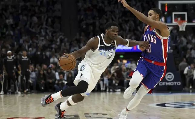 Minnesota Timberwolves guard Anthony Edwards (5) dribbles around Sacramento Kings forward Keegan Murray (13) during the second half of an NBA basketball game, Wednesday, Nov. 27, 2024, in Minneapolis. (AP Photo/Ellen Schmidt)