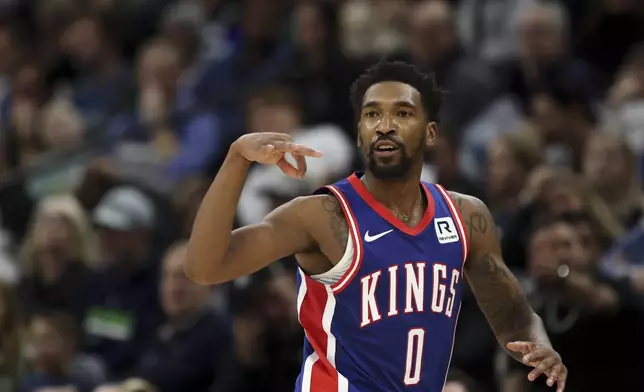 Sacramento Kings guard Malik Monk (0) celebrates after scoring a three-point basket during the second half of an NBA basketball game against the Minnesota Timberwolves, Wednesday, Nov. 27, 2024, in Minneapolis. (AP Photo/Ellen Schmidt)