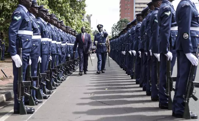 Kenyan President William Ruto, center, reviews the honour guard after arriving to give the State of The Nation address at Parliament buildings in Nairobi, Kenya Thursday, Nov. 21, 2024. (AP Photo/Brian Inganga)