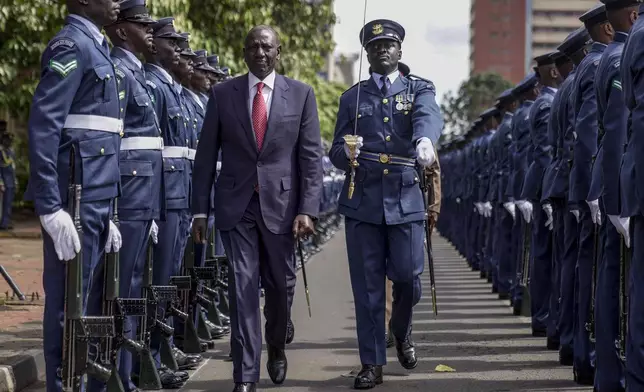 Kenyan President William Ruto, center, reviews the honour guard after arriving to give the State of The Nation address at Parliament buildings in Nairobi, Kenya Thursday, Nov. 21, 2024. (AP Photo/Brian Inganga)