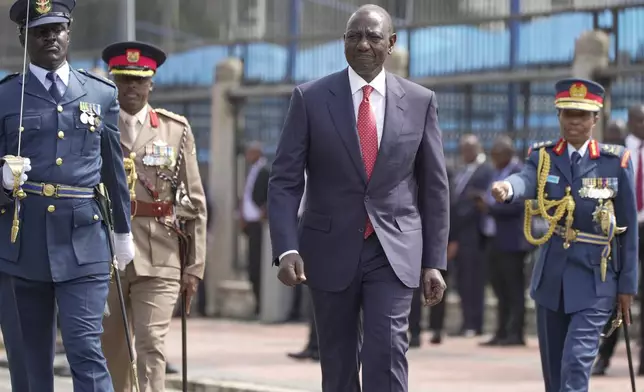 Kenyan President William Ruto, center, reviews the honour guard after arriving to give the State of The Nation address at Parliament buildings in Nairobi, Kenya Thursday, Nov. 21, 2024. (AP Photo/Brian Inganga)