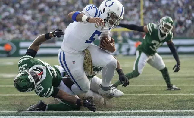 Indianapolis Colts quarterback Anthony Richardson (5) breaks a tackle against New York Jets safety Jalen Mills (35) as he crosses the goal line to score a touchdown during the second quarter of an NFL football game, Sunday, Nov. 17, 2024, in East Rutherford, N.J. (AP Photo/Seth Wenig)