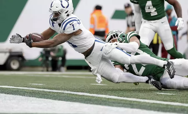 Indianapolis Colts wide receiver Josh Downs (1) extends the ball over the goal line for a touchdown against New York Jets cornerback Isaiah Oliver (23) during the fourth quarter of an NFL football game, Sunday, Nov. 17, 2024, in East Rutherford, N.J. (AP Photo/Adam Hunger)