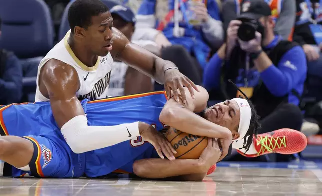 Oklahoma City Thunder forward Ousmane Dieng, right, secures the ball against New Orleans Pelicans center Trey Jemison III, left, during the second half of an NBA basketball game Wednesday, Nov. 13, 2024, in Oklahoma City. (AP Photo/Nate Billings)