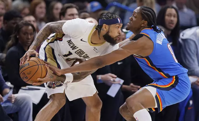 Oklahoma City Thunder forward Jalen Williams, right, tries to steal the ball from New Orleans Pelicans forward Brandon Ingram, left, during the first half of an NBA basketball game Wednesday, Nov. 13, 2024, in Oklahoma City. (AP Photo/Nate Billings)