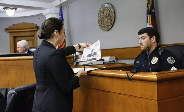 Prosecutor Sheila Ross shows a piece of evidence to University of Georgia Police Josh Epps during the trial of Jose Ibarra at Athens-Clarke County Superior Court on Monday, Nov. 18, 2024, in Athens, Ga. (Miguel Martinez/Atlanta Journal-Constitution via AP, Pool)