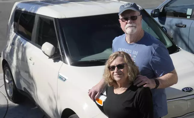 Roxanne and Ken Honeycutt pose for photos by their Kia Soul electric vehicle in San Lorenzo, Calif., Saturday, Nov. 9, 2024. (AP Photo/Jeff Chiu)