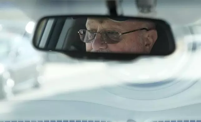 Ken Honeycutt is reflected in the rear view mirror while giving a demonstration of his Kia Soul electric vehicle in San Lorenzo, Calif., Saturday, Nov. 9, 2024. (AP Photo/Jeff Chiu)