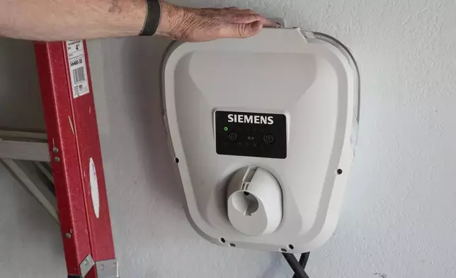 Ken Honeycutt shows a Siemens electric vehicle charger in his garage in San Lorenzo, Calif., Saturday, Nov. 9, 2024. (AP Photo/Jeff Chiu)