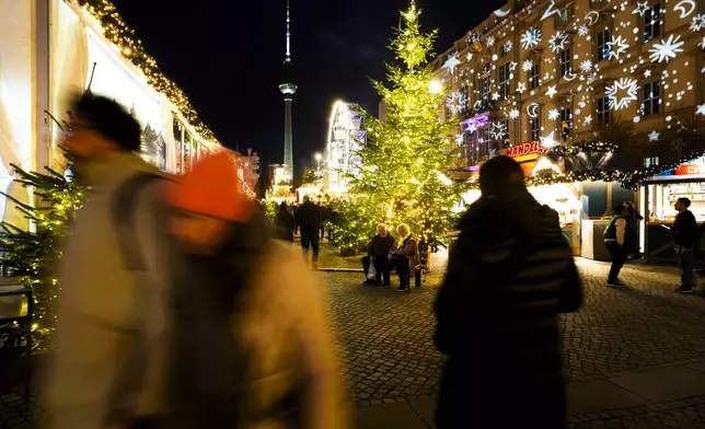 People visit the Christmas market Humbolt Forum on its opening day in the city center of Berlin, Germany, Monday, Nov. 25, 2024. (AP Photo/Markus Schreiber)