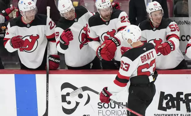 New Jersey Devils left wing Jesper Bratt (63) is congratulated by teammates after he scored during the first period of an NHL hockey game against the Florida Panthers, Thursday, Nov. 14, 2024, in Sunrise, Fla. (AP Photo/Wilfredo Lee)