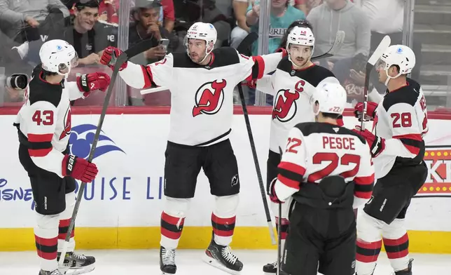 New Jersey Devils right wing Stefan Noesen, second from left, celebrates with teammates after he scored during the first period of an NHL hockey game against the Florida Panthers, Thursday, Nov. 14, 2024, in Sunrise, Fla. (AP Photo/Wilfredo Lee)