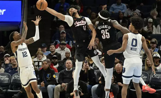 Portland Trail Blazers guard Shaedon Sharpe (17) reaches for the ball ahead of Memphis Grizzlies guard Ja Morant (12) in the first half of an NBA basketball game Monday, Nov. 25, 2024, in Memphis, Tenn. (AP Photo/Brandon Dill)