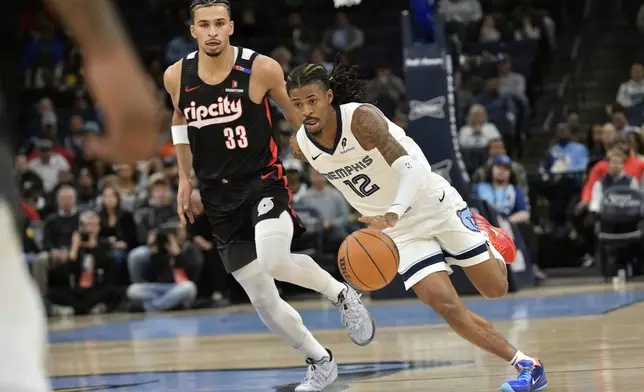 Memphis Grizzlies guard Ja Morant (12) handles the ball ahead of Portland Trail Blazers forward Toumani Camara (33) in the first half of an NBA basketball game Monday, Nov. 25, 2024, in Memphis, Tenn. (AP Photo/Brandon Dill)